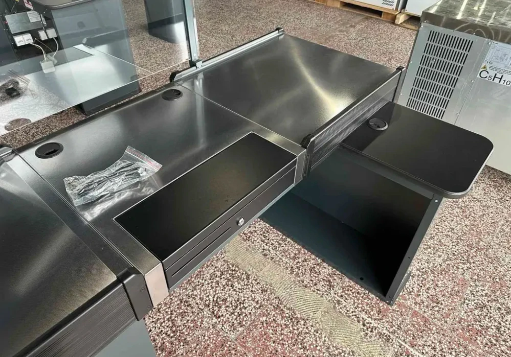 Pokladní box s nepojízdným pásem a úzkým skluzem
